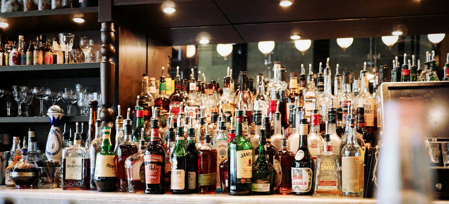 Bar shelf with multiple an assortment of liquor bottles